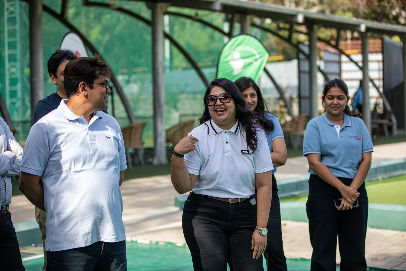 A group of GCC leaders talking and smiling beside the practice area