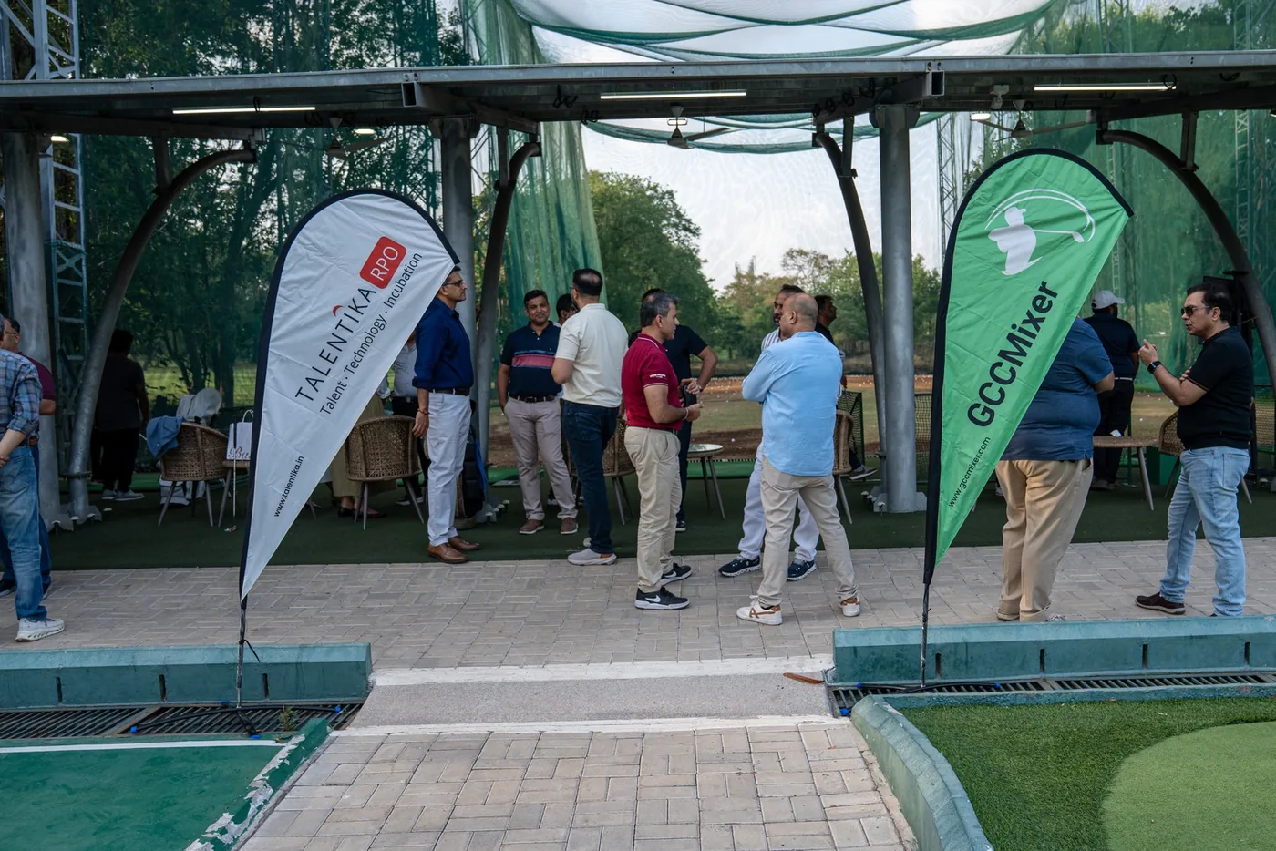 Guests gathering between GCC Mixer flags at the golf club